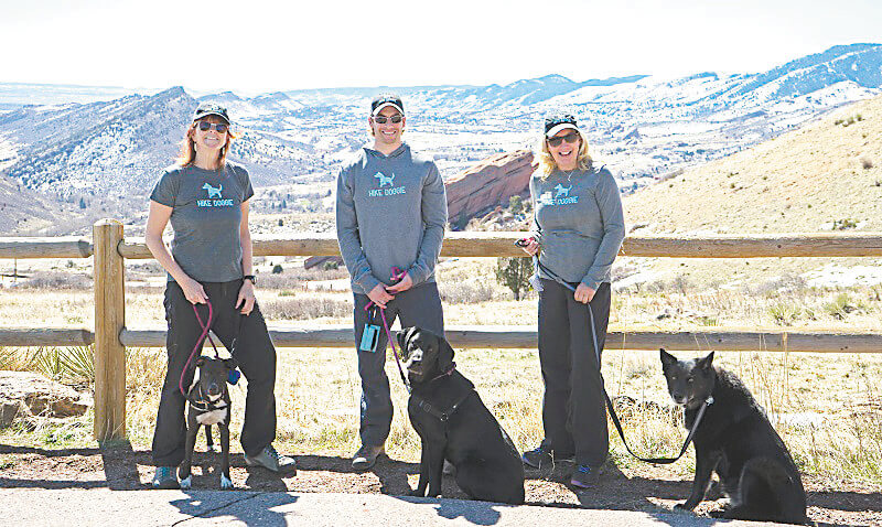 Staff members standing with dogs at scenic overlook