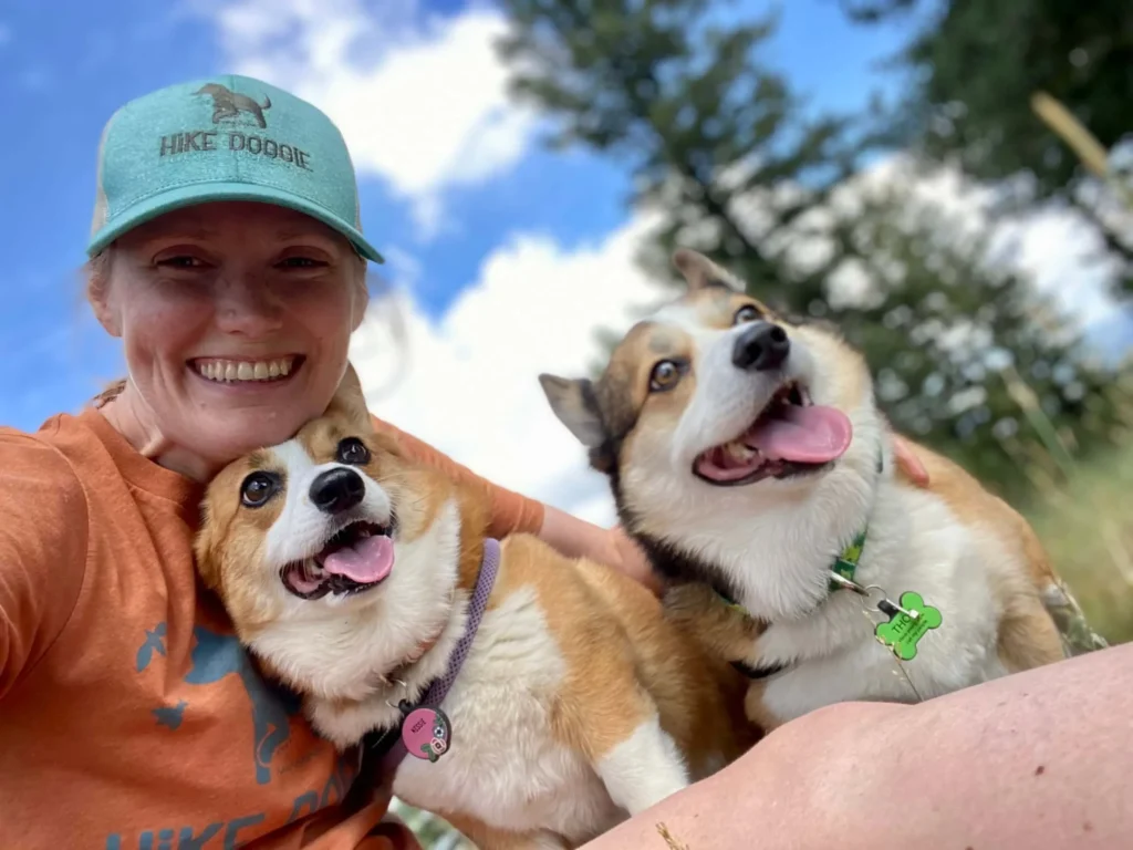 Woman smiling with two dogs selfie outdoors