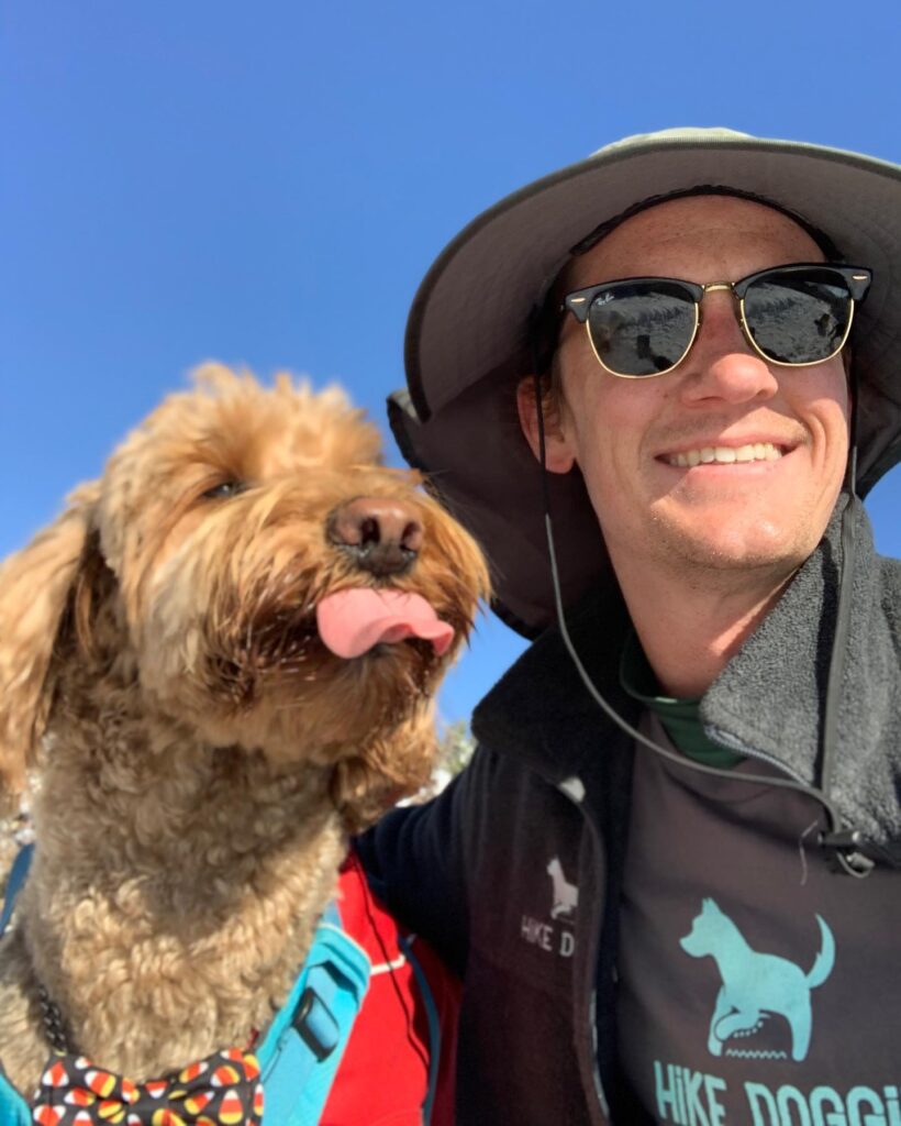 Man smiling with small fluffy Poodle selfie outdoors