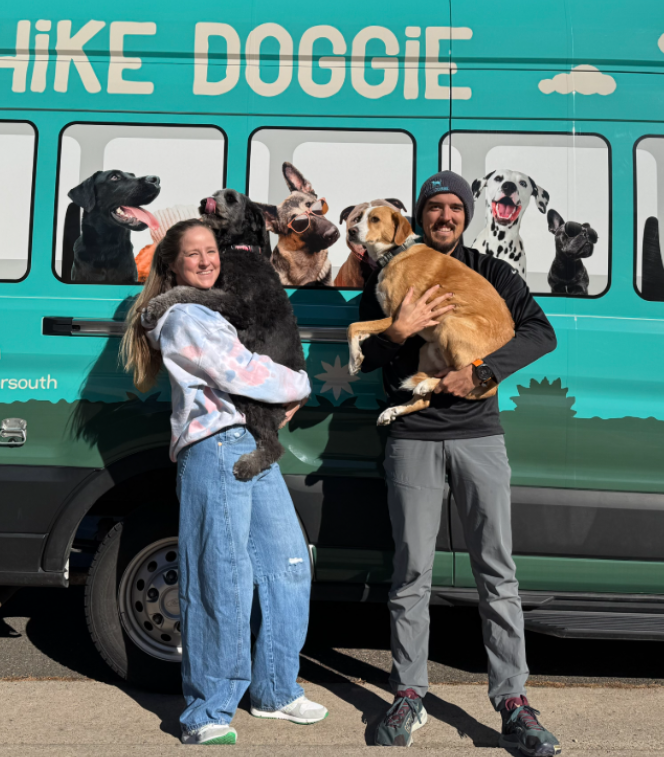 Team members posing with dogs beside Hike Doggie van