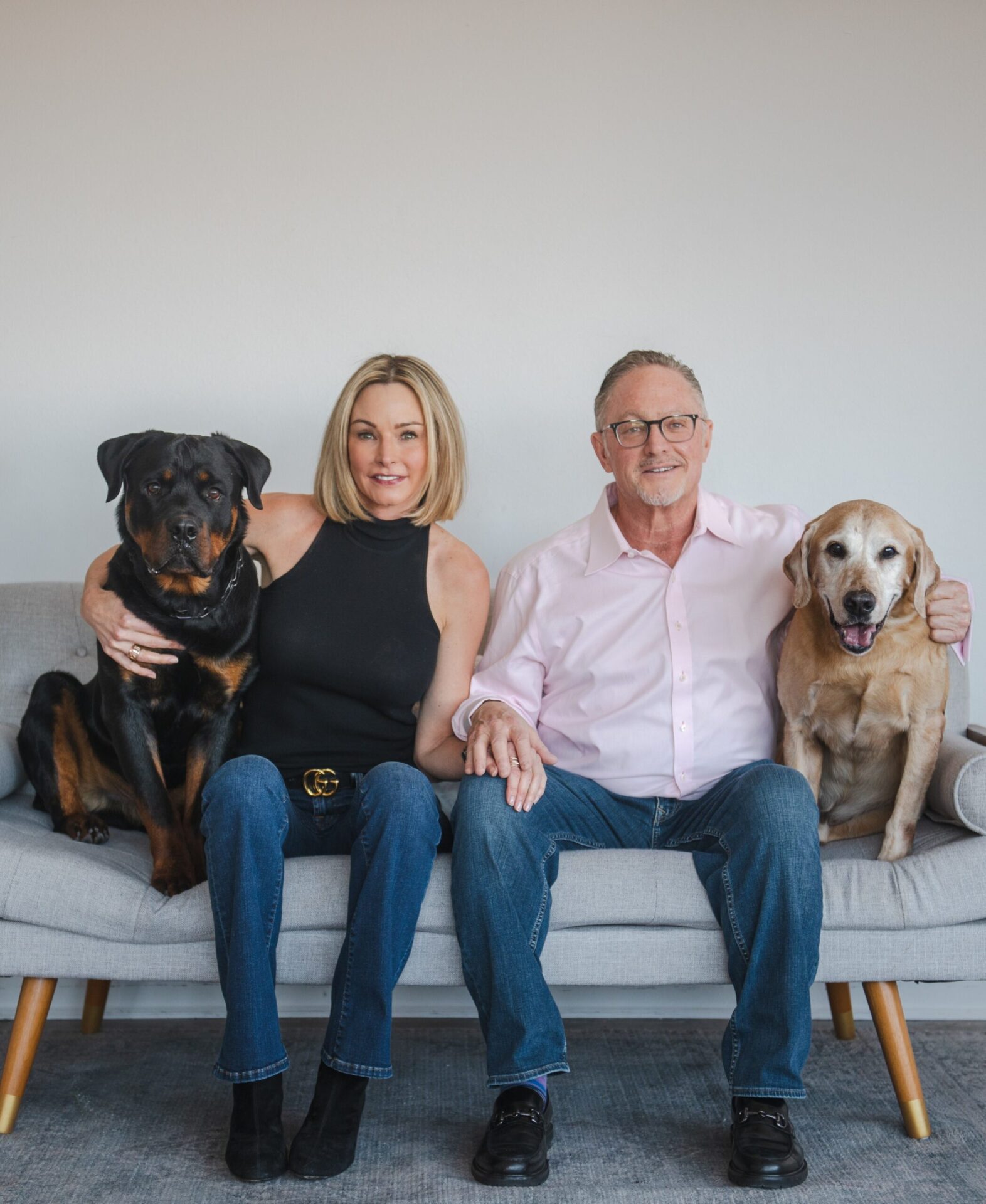 Family seated with Rottweiler and Labrador dogs, trusted local dog walking clients