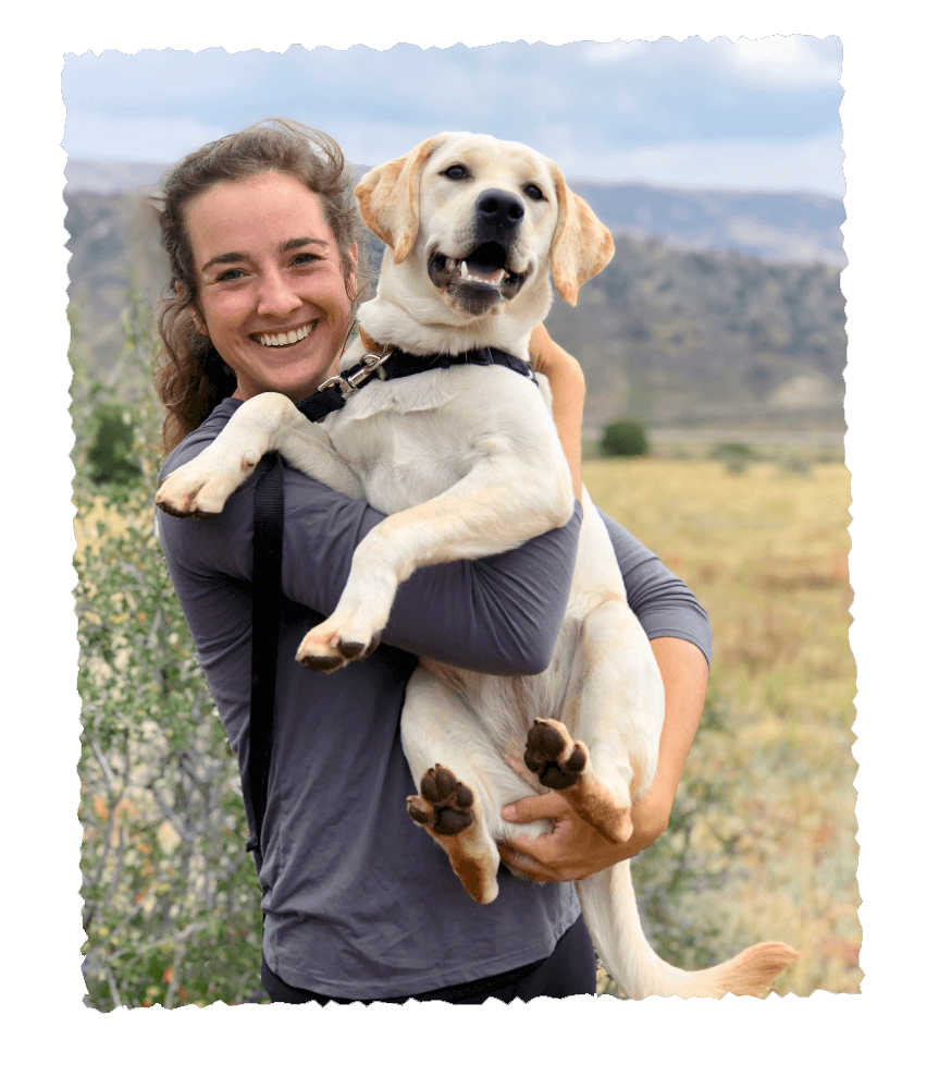 Woman holding happy retriever after trail walk