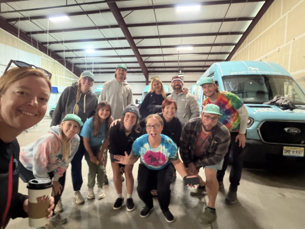 Group of people and dogs inside facility, community dog event