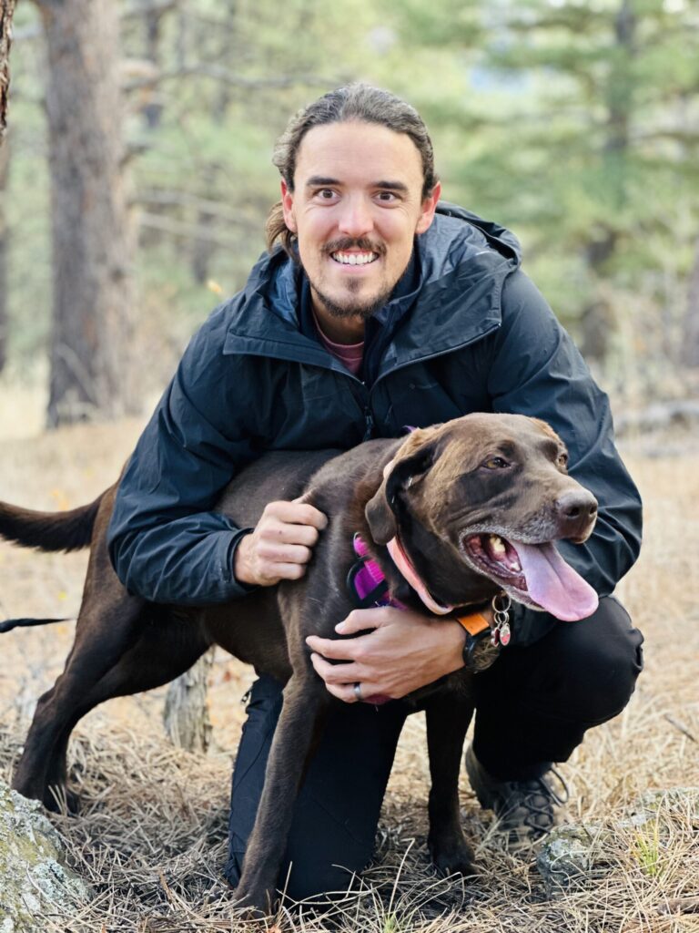 Man kneeling and hugging happy dog outdoors