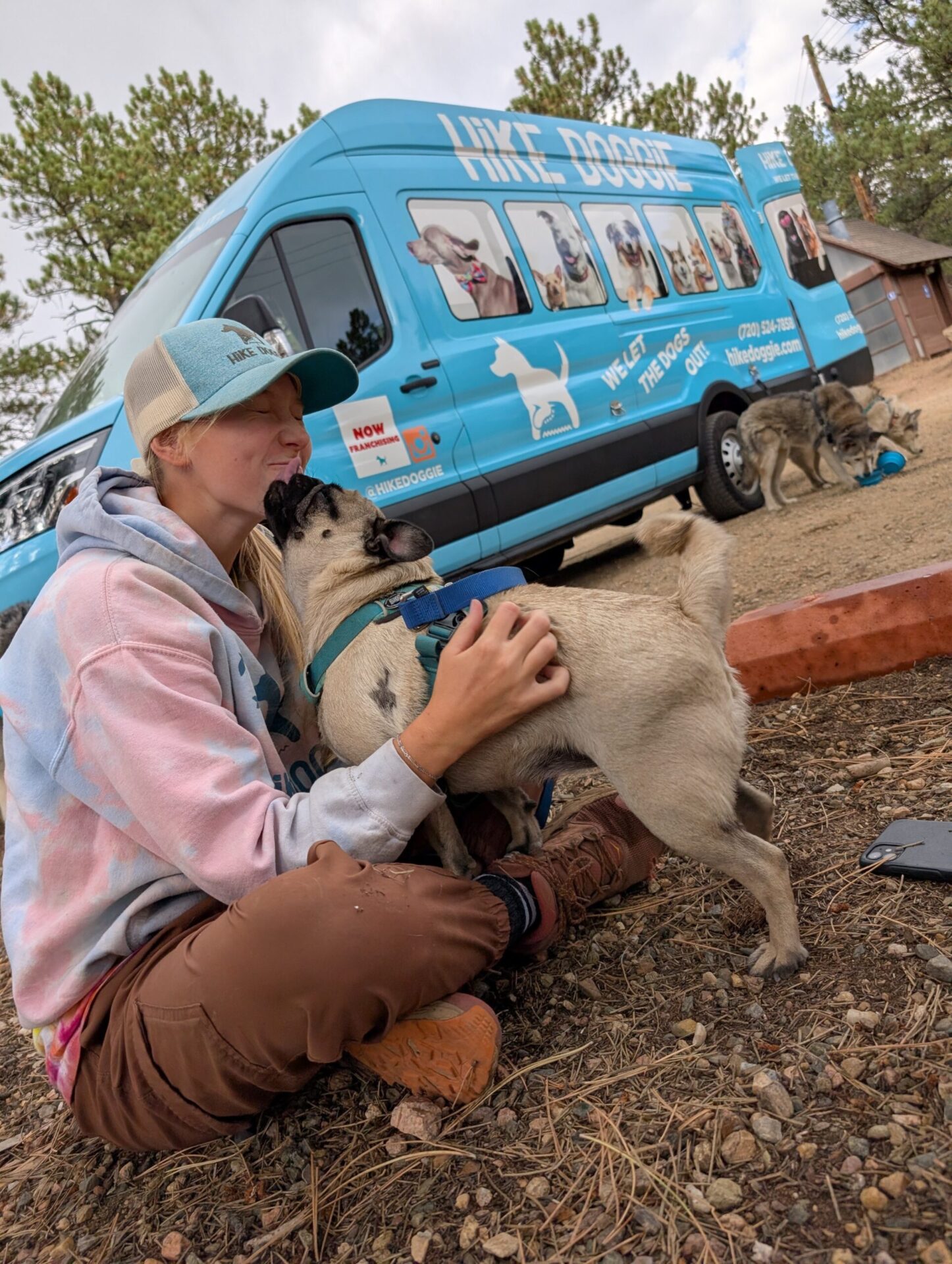 Handler petting dog beside Hike Doggie van