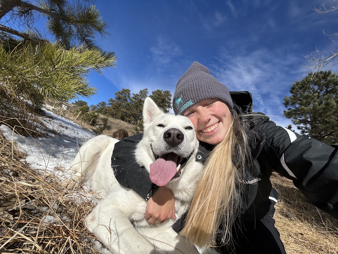 Woman hugging white dog outdoors in winter